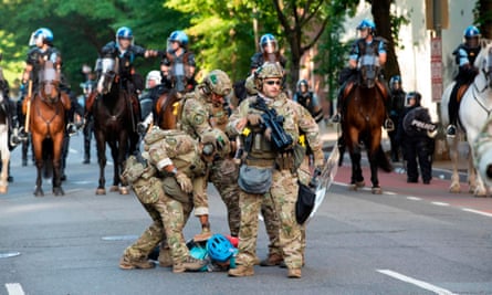 Military police officers are restraining a protester near the White House on Monday.
