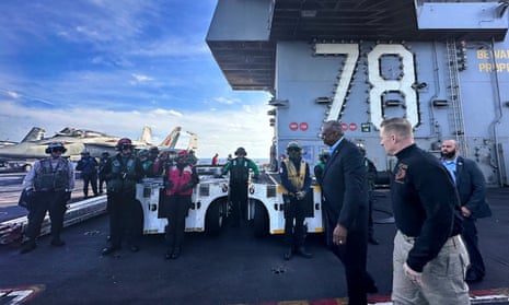 US defence secretary Lloyd Austin, front left, walks next to the commanding officer of the USS Gerald R. Ford, Navy Capt. Rick Burgess, front, during an unannounced visit to the ship on Wednesday. The aircraft carrier has been sailing just a few hundred miles off the coast of Israel.