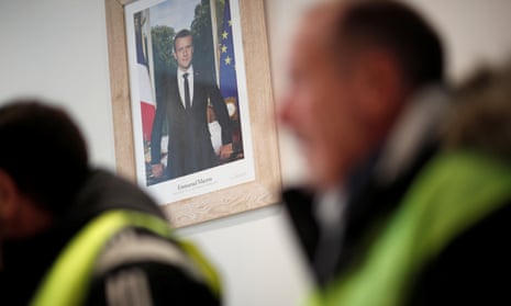 The official portrait of French President Emmanuel Macron is seen during a meeting with yellow vests movement members