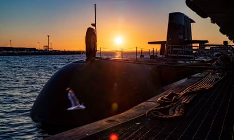 the sun rises over a Royal Australian Navy submarine