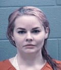 A mugshot of a woman with pink hair