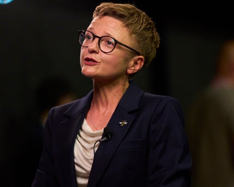 Bev Craig, wearing a bee pin, speaks into a microphone after her byelection win