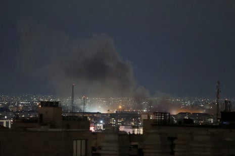 A plume of smoke rises from the site of an airstrike in Tehran early on 28 March, following Israeli attacks.