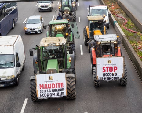 Farmers in tractors driving down a road