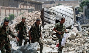 Forces loyal to President Assad walk past rubble in Aleppo