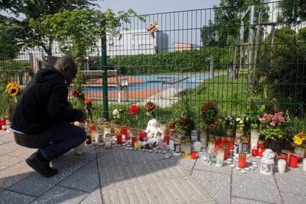 A man lights a candle at a makeshift memorial site in front of the school.