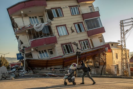 A pedestrian passes a collapsed building in Kahramanmaraş, southerrn Turkey