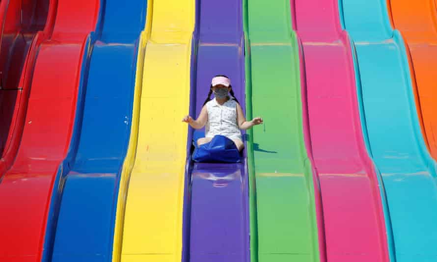 A young girl wearing a mask slides down on a ride as the Calgary Stampede gets underway following a year off due to COVID-19 restrictions, in Calgary, Alberta, Canada.
