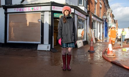Louise Preston outside her shop with a boarded-up window