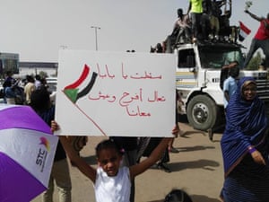 A young girl holds a protest sign during the rally
