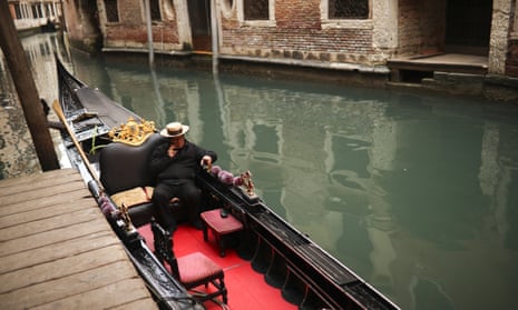 A gondolier talks on his smartphone as he waits for clients in Venice.