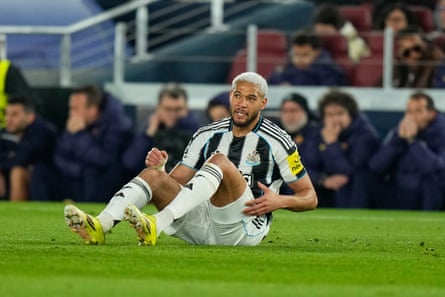 Newcastle’s Joelinton sits on the ground at the Camp Nou