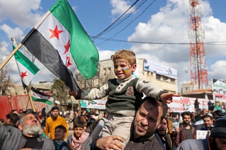 A Syrian boy with his face painted in the colours of the Ukranian flag, attends a rally marking 11 years since an anti-regime uprising in Syria’s rebel enclave of Idlib