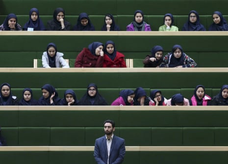 A security guard stands by while Iranian school girls attend an open session of parliament in Tehran.