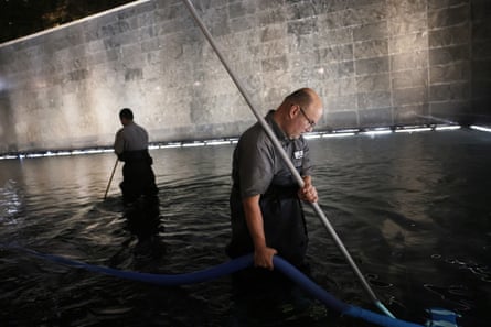 People clean a reflecting pool
