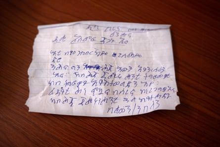 A piece of paper with blue biro writing on it is now unfolded on a table.