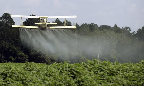 A crop duster sprays a field of crops in Alabama. 