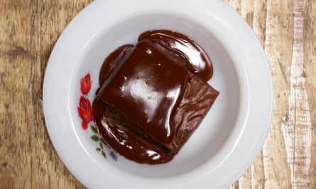 dark chocolate brownie with chocolate sauce on a plate