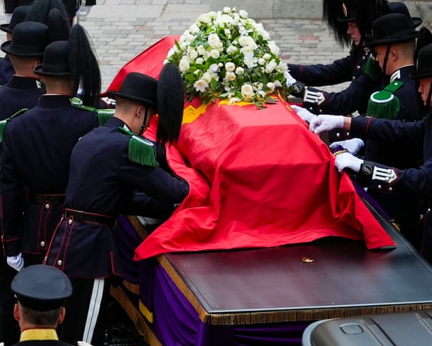 King Harald V's coffin draped in a red sheet and surrounded by soldiers