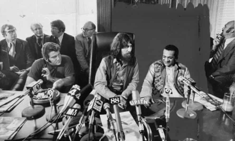 George Harrison (center), flanked by Allen Klein (left) and Ravi Shankar, talks to journalists about their benefit show for East Pakistani refugee children in Madison Square Garden, 1971.
