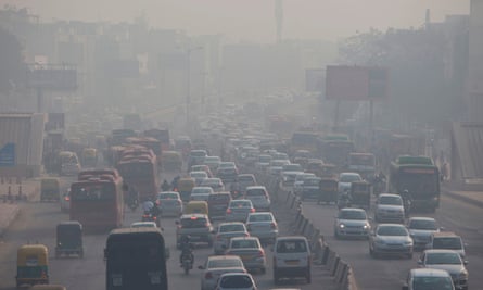 Indian commuters drive amidst heavy smog along a busy road in New Delhi.