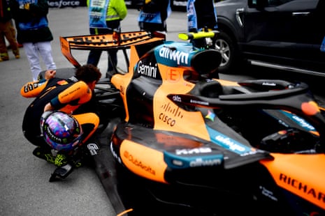 Lando Norris inspects his car after retiring.