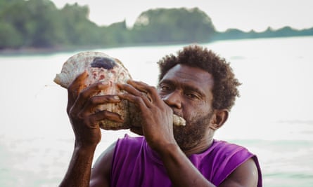 Amos Lavaka blowing a conch shell at Messi village