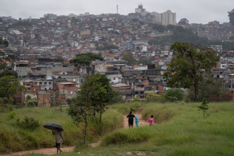 A family walk along a path through a park on the outskirts of a city.
