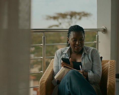 Patricia Kingori sits in an armchair and speaks into a phone