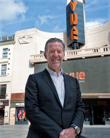 Richards posing smiling for a portrait outside a Vue cinema in an imposing old building, in cream, grey and orange livery