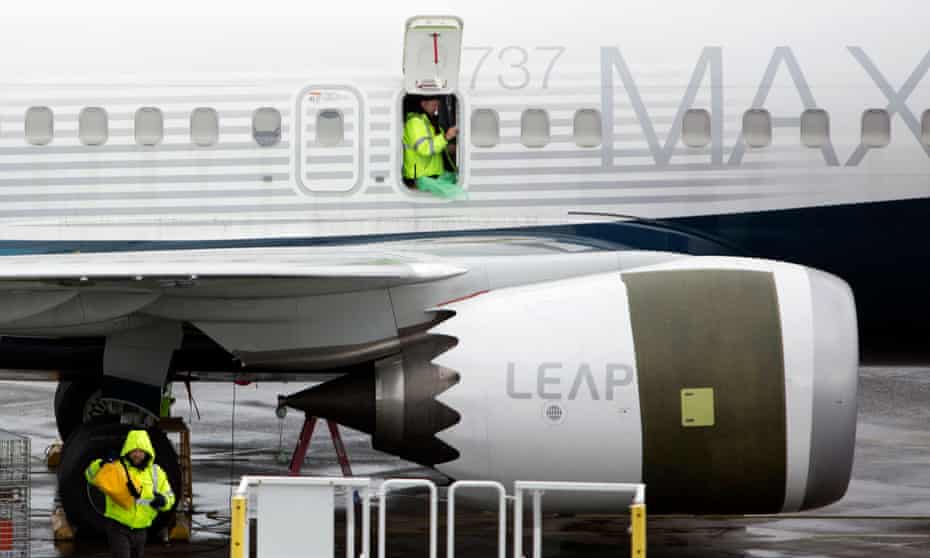 Workers are shown next to a Boeing 737 MAX 9 airplane on the tarmac at the Boeing Renton factory in Washington.