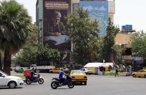 A billboard with a picture of Benjamin Netanyahu in military fatigues and hemlet looking at a map is seen across a square with traffic in the foreground