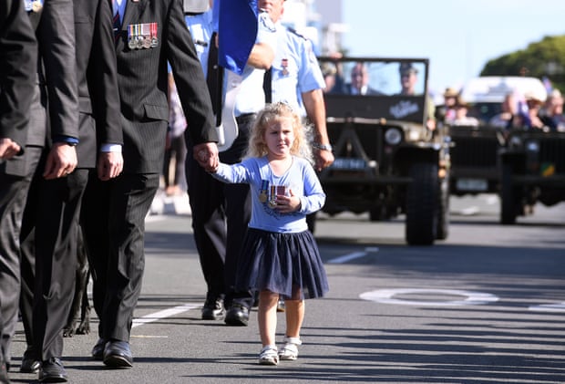 A young girl is seen wearing medals during an Anzac Day march in Southport on the Gold Coast , Tuesday, April 25, 2017