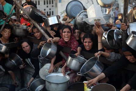 Palestinians wait to receive food in the Al-Rimal neighbourhood of central Gaza City, on 20 July 2025.