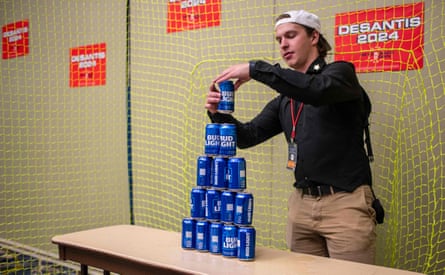 An employee builds a tower of Bud Light beer cans for ball target practice at the Republican party of Iowa’s 2023 Lincoln Dinner in July.