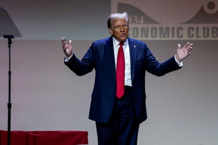 Donald Trump raises his arms in a godlike pose onstage