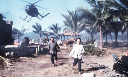 Extras run from a helicopter during filming