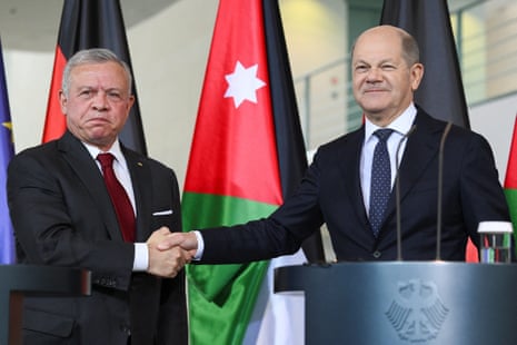 Olaf Scholz (R) and King Abdullah II shake hands