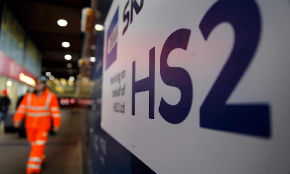 A worker walks past a sign outside a construction site for a section of the HS2 high-speed railway project