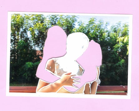 A woman sits on a bench in a park with a child behind her over each shoulder. The children are reaching forwards to hug the woman. Their faces have been obscured