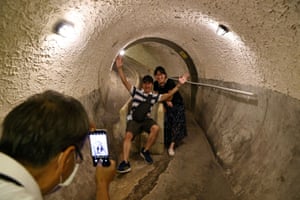 Tourists pose for photos at an underground tunnel