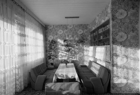 A black and white photo of sofas and flowery wallpaper