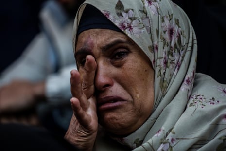 A woman mourns as people collect the bodies of Palestinians killed in an Israeli airstrike in Khan Younis.