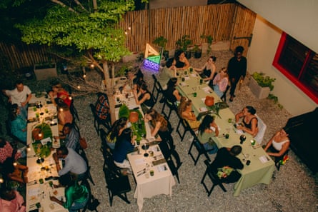 Several people, seen from overhead, chatting over dinner at three long tables