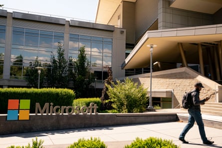 A man walking by a Microsoft sign.