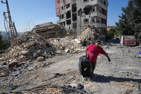A man carries a bag after he collected some of his belongings from his destroyed house in Nabatiyeh southern Lebanon.