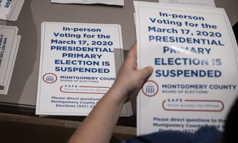 County election workers hand out election delayed signs to put up at polling stations in Dayton, Ohio on Tuesday after the primaries were canceled.