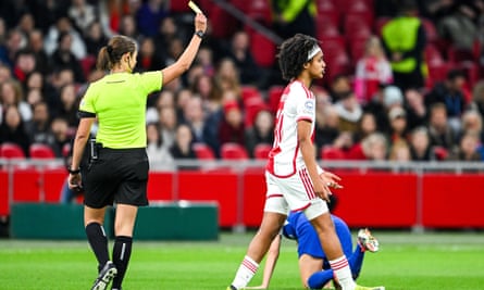 Maria Caputi shows Lily Yohannes a yellow card during the first leg of the 2023-24 Women’s Champions League quarter-final match between Ajax and Chelsea at the Johan Cruyff Arena in Amsterdam on 19 March 2024