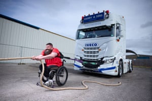 Dave Walsh in wheelchair pulling truck by thick rope