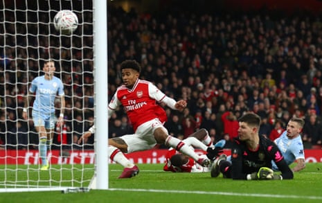 Arsenal’s Reiss Nelson bundles the ball over the line.